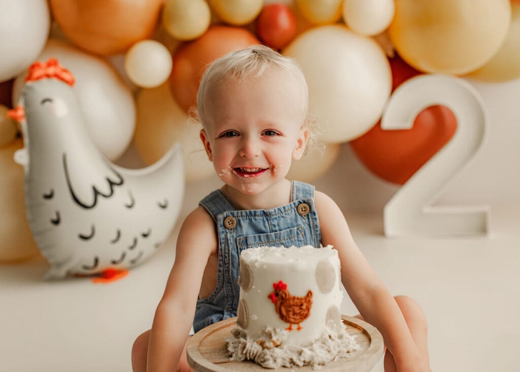 toddler boy smiling during cake smash photography session