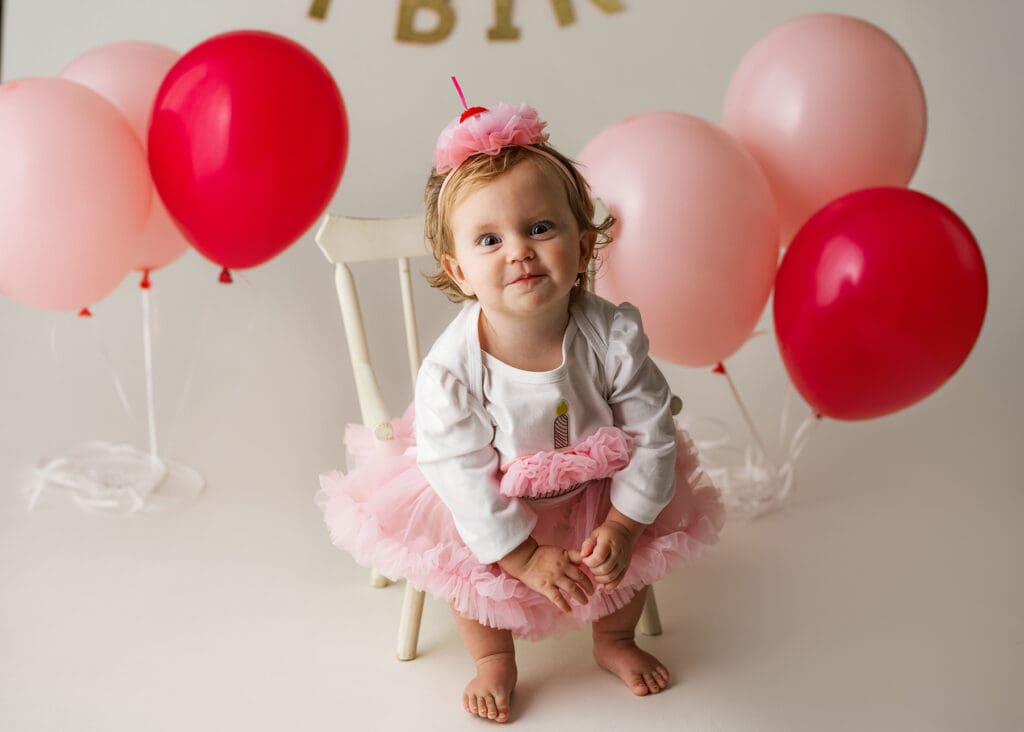 one-year-old girl making a silly face during her cake smash photo session