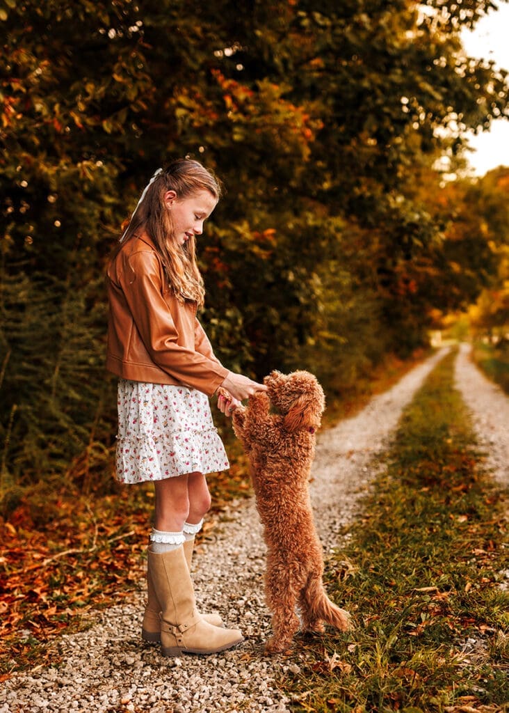 girl dancing with her dog during fall family photos