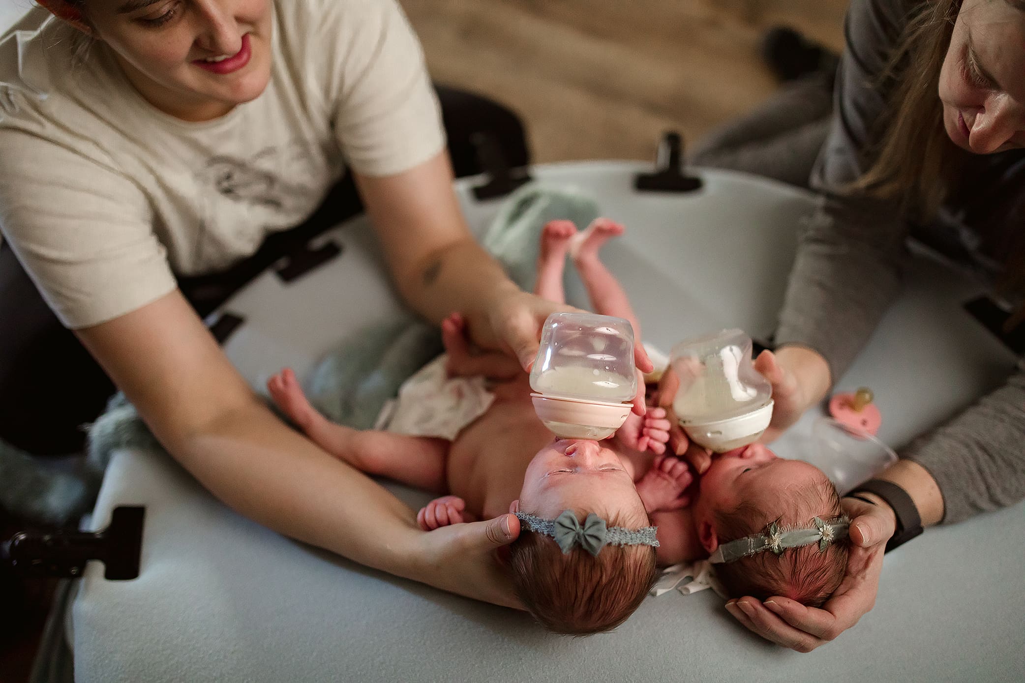Clarksville Newborn Photographer Jess Pearson feeds twin newborns during studio photography session