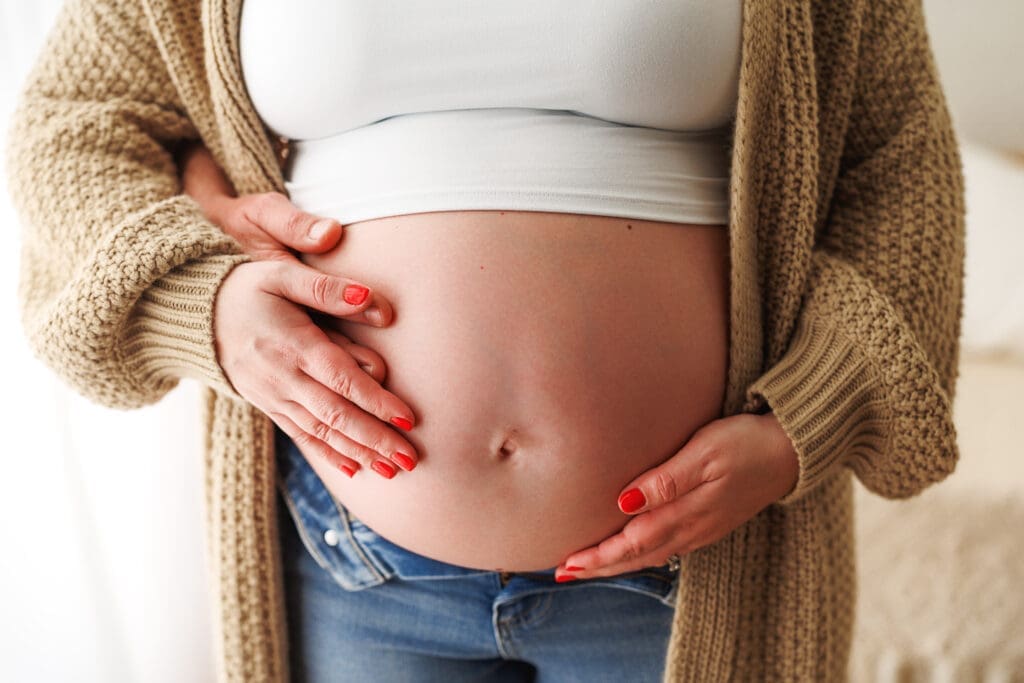 photo of a pregnant woman holding her baby bump at clarksville studio
